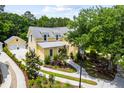 Aerial view of a charming two-story yellow home with a detached garage and lush landscaping at 3413 Acorn Drop Ln, Johns Island, SC 29455