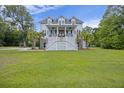 Inviting two-story home featuring a charming front porch and a well-manicured lawn at 4205 Cobble Trot Way, Johns Island, SC 29455