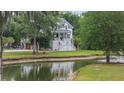 Beautiful home surrounded by lush greenery and a tranquil pond with a fountain at 4205 Cobble Trot Way, Johns Island, SC 29455