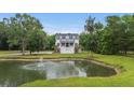 Scenic aerial view of a home with a lovely pond featuring a fountain and lush greenery at 4205 Cobble Trot Way, Johns Island, SC 29455