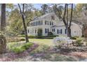 Beautiful two-story home featuring a covered porch and a well-manicured lawn with flowering plants at 4233 Lady Banks Ln, Ravenel, SC 29470