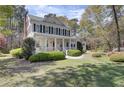 Charming two-story home with a inviting front porch, black shutters and mature landscaping at 4233 Lady Banks Ln, Ravenel, SC 29470