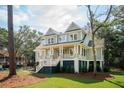Inviting two-story home with a charming front porch, surrounded by mature trees and a well-manicured lawn at 4291 Turtle Landing Ct, Johns Island, SC 29455