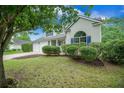 Charming two-story home featuring blue shutters and an arched window with manicured landscaping at 5406 Woodbreeze Dr, North Charleston, SC 29420