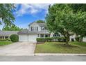 Charming two-story home featuring blue shutters, a well-maintained lawn, and an attached two-car garage at 5406 Woodbreeze Dr, North Charleston, SC 29420