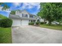 Well-maintained two-story home with attached garage, lush lawn, and manicured landscaping at 5406 Woodbreeze Dr, North Charleston, SC 29420