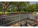 Beautiful deck with wooden flooring, white railing, and black chairs overlooking a lush green space at 55 Fairway Dunes Ln # Week 2, Isle of Palms, SC 29451