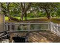 Relaxing deck with wooden flooring, white railing, and chairs overlooking a lush green space at 55 Fairway Dunes Ln # Week 2, Isle of Palms, SC 29451