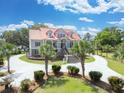 Elegant exterior showcasing a two-story home with a prominent staircase and a circular driveway at 5625 Crystal Harbor Ln, Hollywood, SC 29449
