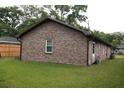Back exterior of a brick house with a well-kept lawn and fenced in yard at 814 Armsway St, Mount Pleasant, SC 29464