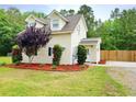 Charming two-story home with manicured landscaping, including decorative mulch and well-kept shrubs at 9489 Sidneys Rd, Round O, SC 29474