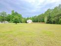 Expansive grassy yard surrounding a home, bordered by a wooden fence and mature trees at 9489 Sidneys Rd, Round O, SC 29474