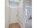 Inviting entryway with wood-look floors and white door leading to a spacious living area at 1003 Peridote Way, Ladson, SC 29456