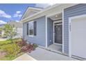 Close-up of front porch with light blue siding, a door with a wreath, and well maintained landscaping at 1003 Peridote Way, Ladson, SC 29456
