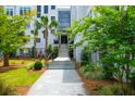 Inviting entryway with lush landscaping and a stone path leading to the building's entrance at 108 Fairbanks Oak Aly # 401, Charleston, SC 29492