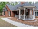 Close up of the wraparound porch with chairs and brick flooring at 111 Coltsgate Ct, Summerville, SC 29485