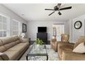 Bright living room with neutral paint, dark floors, large windows, ceiling fan, and comfortable sofas and seating at 1110 Flyway Rd, Summerville, SC 29483