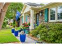 Charming brick home with teal shutters, inviting front porch adorned with vibrant flowers at 1158 Shoreside Way, Mount Pleasant, SC 29464