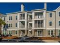 Multi-level condo building showcasing large balconies, a palm tree, and reserved parking spaces at 130 River Landing Dr # 7106, Charleston, SC 29492