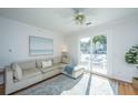 Comfortable living room boasts bright natural light, a large sofa, and easy access to outdoor balcony at 130 River Landing Dr # 7106, Charleston, SC 29492