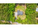 An aerial view shows a secluded home with a spacious yard, fire pit, and driveway, all surrounded by lush trees at 1375 Tannanger Trl, Awendaw, SC 29429
