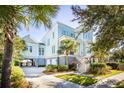 Beautiful raised home showcasing garage, lush landscaping, and a charming staircase at 1410 Smythe St, Charleston, SC 29492