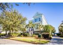 Charming light blue two-story home featuring manicured landscaping and a welcoming front porch at 1410 Smythe St, Charleston, SC 29492
