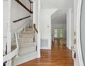 Bright foyer features hardwood floors, a winding staircase, and views into the adjacent rooms at 143 Belleplaine Dr, Goose Creek, SC 29445