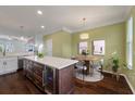Eat-in kitchen featuring a quartz island with wine fridge, pendant lighting, and a dining table at 1533 Bluewater Way, Charleston, SC 29414