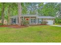 Charming brick home with a red front door, classic shutters, and lush green lawn at 206 Jimbo Rd, Summerville, SC 29485