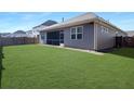 Spacious backyard with lush green grass, a screen porch and privacy fence at 209 Celestial Blvd, Summerville, SC 29486