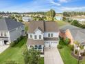 Aerial view of charming home near a tranquil lake, with a manicured lawn, two-car garage, and inviting porch at 246 Calm Water Way, Summerville, SC 29486