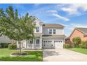 Charming two-story home with a manicured lawn, two-car garage, and inviting porch with blue furniture at 246 Calm Water Way, Summerville, SC 29486
