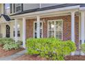 Townhome's brick porch with white columns, lush green bushes, and visible unit number at 302 Elm Hall Cir, Summerville, SC 29483