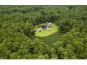 An aerial view of the house in the woods, nestled on a large lot and serene pond at 3113 Edenvale Rd, Johns Island, SC 29455