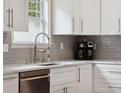 Kitchen featuring white cabinets, gray backsplash, stainless steel appliances, and modern fixtures at 3113 Edenvale Rd, Johns Island, SC 29455