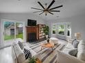 Bright living room featuring a fireplace, bay window, ceiling fan, and sliding glass doors to the backyard at 4500 Winterwood Pl, Ladson, SC 29456