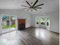 Bright living room featuring a fireplace, bay window, ceiling fan, and sliding glass doors to the backyard at 4500 Winterwood Pl, Ladson, SC 29456