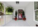 Inviting covered front porch with a decorative front door and stylish potted plants on a wood deck at 638 Stono Edge Dr, Charleston, SC 29412