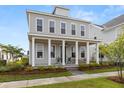Beautiful two-story home featuring a welcoming front porch with classic white columns and lush landscaping at 716 Triangle Ln, Summerville, SC 29486
