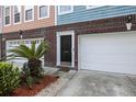 Close-up of townhome exterior with brick base, garage, and a well-manicured front yard at 9019 Parlor Dr, Ladson, SC 29456