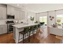 Modern kitchen with gray cabinets, stainless appliances, a center island with seating, and an open dining area at 105 Indigo Cove Blvd, Summerville, SC 29486