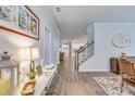 Inviting hallway with hardwood floors that leads to a modern kitchen and staircase at 120 Loon Dr, Summerville, SC 29483