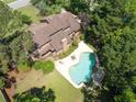 Stunning aerial view showcasing the backyard swimming pool, mature trees, and outdoor patio area at 1218 Chersonese Round, Mount Pleasant, SC 29464