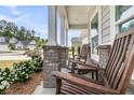 Relax on this home's covered front porch with classic rocking chairs and brick-based columns at 1273 Locals St, Summerville, SC 29485