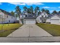 Charming two-story home with gray siding, an attached garage, a well-manicured lawn, and lush, mature trees at 164 Wappoo Trace Ln, Summerville, SC 29486