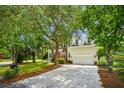 Charming two-story home with brick and siding, mature trees, an orange front door, and an attached garage at 174 Revetment Ln, Mount Pleasant, SC 29464