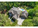 Aerial view of a brick home with a private backyard pool and lush landscaping, nestled among tall trees at 2221 Black Oak Ct, Mount Pleasant, SC 29466
