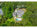 Sprawling home with a backyard pool and screened-in porch, surrounded by a canopy of mature trees at 2221 Black Oak Ct, Mount Pleasant, SC 29466