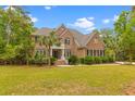Traditional brick home with a symmetrical facade, complemented by mature landscaping and a healthy green lawn at 2221 Black Oak Ct, Mount Pleasant, SC 29466
